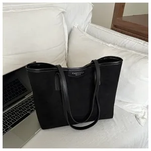 Dettaglio ravvicinato di una grande borsa tote in pelle scamosciata nera con manici in pelle