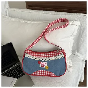 Detail of sweet blue denim bag featuring red checkered trim and white lace edges
