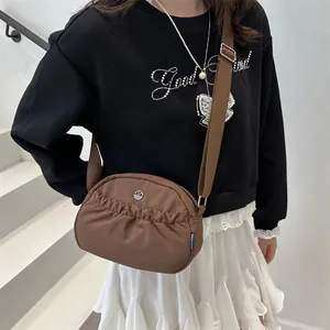 Brown pleated crossbody bag for women with adjustable strap and metal logo accent
