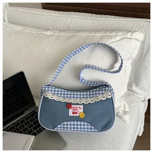Close-up of denim patchwork shoulder bag with plaid patterns and lace trim details