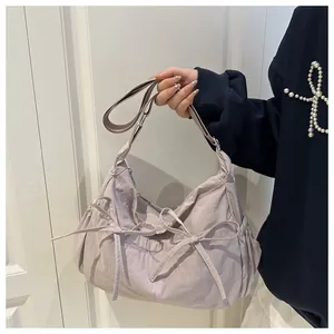 Detail of light purple nylon shoulder bag with cute bow accents and gathered texture