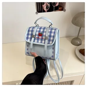 Detail of light blue checkered mini bag with apple embroidery and top handle grip