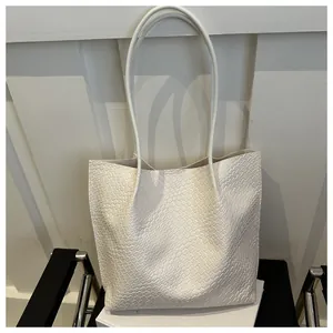 Close-up of white woven tote bag texture with slim straps on a designer chair