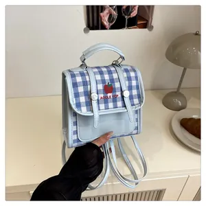 Detail of blue plaid checkered square bag showing apple print and versatile straps