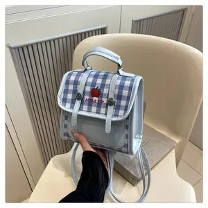Detail of light blue checkered mini backpack with apple embroidery and PU leather straps