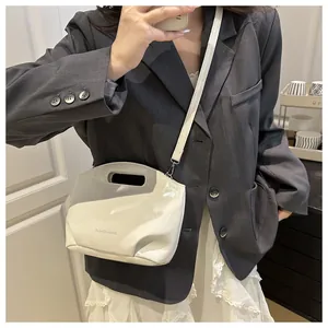 Detail of cream glossy leather handbag with FASHION & BAGS print and adjustable strap