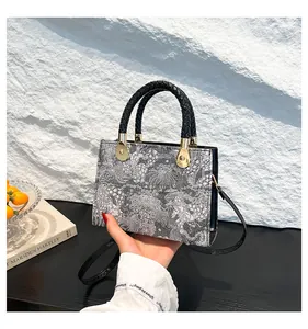 Dettaglio di borsa quadrata vintage con tessuto jacquard e manico intrecciato