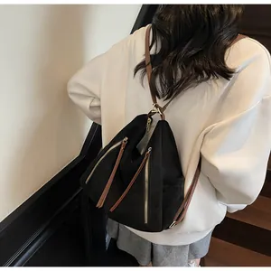 Dettaglio dello zaino vintage in pelle scamosciata nera con cerniere dorate e cinturini