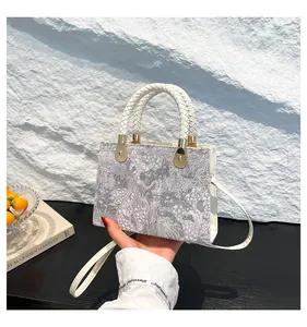 Dettaglio della trama jacquard e del manico intrecciato della borsa a tracolla elegante