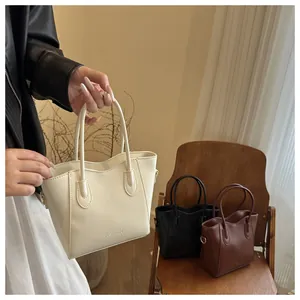 Close-up of premium PU leather bucket bags in cream, black and brown with wavy edge design