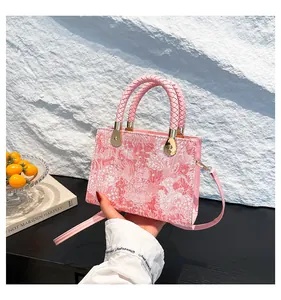 Dettaglio della trama jacquard rosa con manico intrecciato e finiture dorate