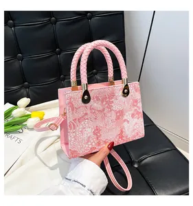 Dettaglio del ricamo jacquard floreale rosa sulla borsa a mano quadrata di lusso