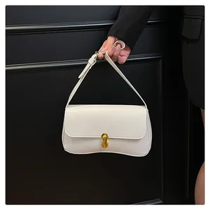 Detail of white leather shoulder bag featuring an elegant gold metal twist lock buckle