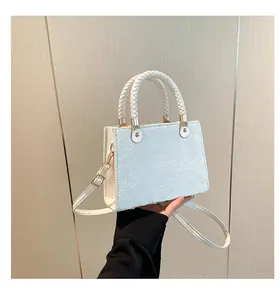 Vue détaillée du motif de rose en relief 3D sur le sac à main rectangulaire blanc