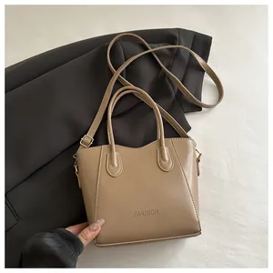 Close-up of khaki bucket bag with adjustable shoulder strap and FASHION embossed logo