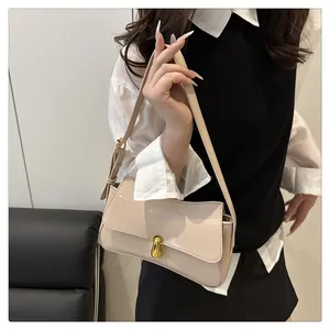 Detail of glossy beige patent leather bag with a stylish gold oval metal lock closure