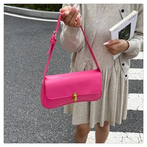 Detail showing the adjustable strap and golden twist lock on a magenta handbag