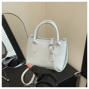Detail of light blue bucket bag with pebble texture and detachable shoulder strap