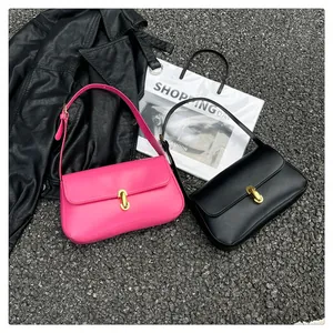 Hot pink and black leather underarm bags with gold buckles shown on asphalt background
