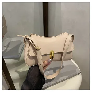 Detail of light beige patent leather bag featuring a gold twist lock and mirror reflection