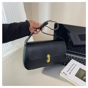 Close-up of black leather square handbag featuring an elegant gold oval metal lock