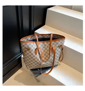 Vista dettagliata della borsa tote grigia con stampa monogramma e manici marroni
