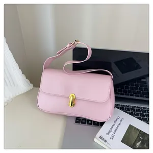 Detail of light pink leather bag featuring a gold U-shaped twist lock closure and smooth texture