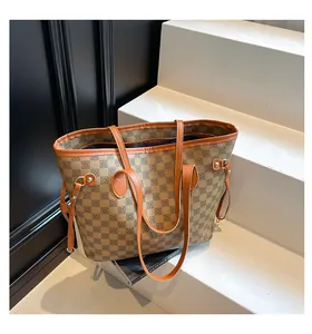 Dettaglio della borsa tote a scacchi con finiture in pelle marrone e coulisse