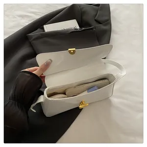 White patent leather handbag interior showing capacity for phone and makeup with gold clasp