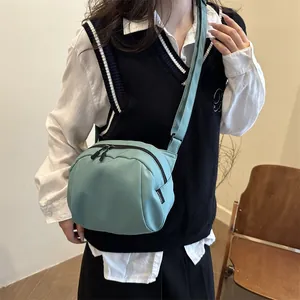 Minimalist light green nylon crossbody bag with adjustable strap and sleek zipper design