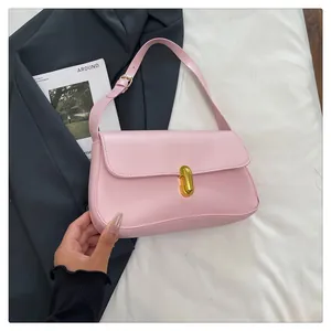 Pink leather shoulder bag featuring a gold capsule metal lock on a soft fabric background
