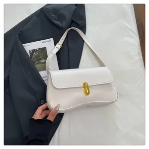 Macro detail of white faux leather shoulder bag with elegant golden capsule metal clasp