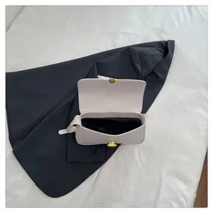 Top view of cream leather shoulder bag open interior with gold twist lock and black lining