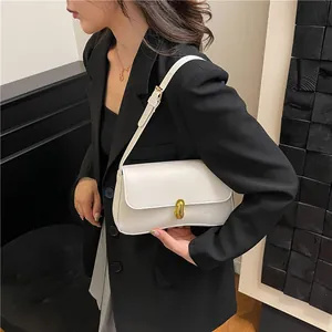 Minimalist white leather shoulder bag with gold twist lock shown on a model