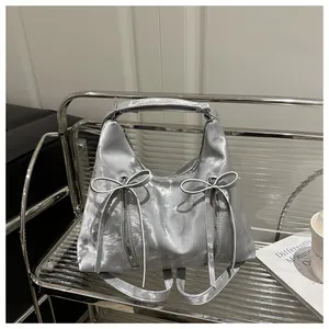 Detail der silbernen Metallic Hobo Bag mit Schleifen-Akzenten und Reißverschluss-Struktur