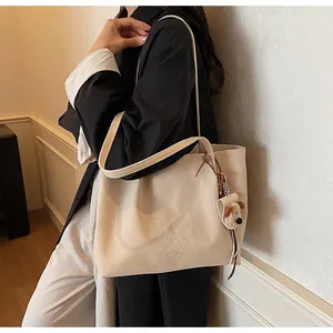 Détail d'un sac cabas en toile avec broderie et charmant chiot en peluche