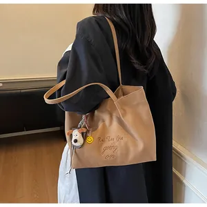 Détail du grand sac cabas en daim kaki avec broderie et pendentif chien peluche