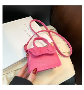 Détail du mini sac bandoulière rose fuchsia avec une texture en cuir PU grainé litchi