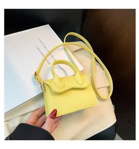 Détail macro du cuir grainé jaune citron et boucle dorée sur le mini sac bandoulière