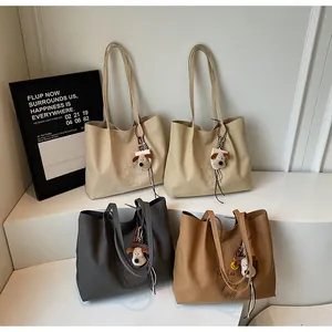 Vue détaillée de quatre sacs fourre-tout en toile brodés avec des breloques de chien