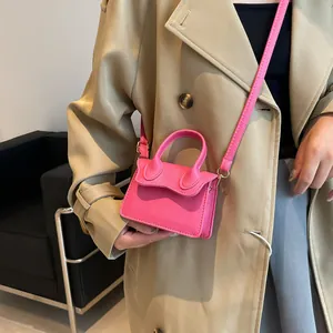 Mini sac bandoulière rose en cuir texturé avec rabat ondulé porté par un mannequin