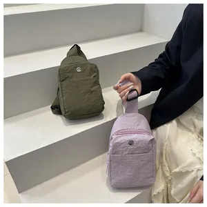 Detail of army green and light purple waist bags featuring crinkled fabric texture