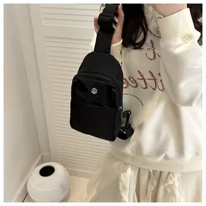 Detail of black waterproof nylon crossbody bag with metal M logo and adjustable strap