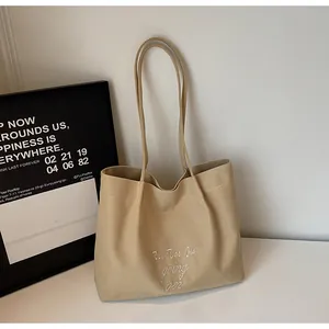 Détail du sac cabas en toile kaki avec broderie de lettres blanches Rui Tao Jia