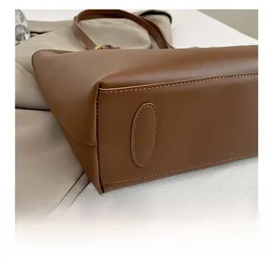 Close-up of the reinforced brown leather tote bag bottom with neat stitching detail