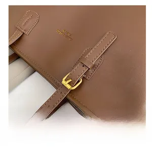 Detail of dark brown leather strap with gold buckle and embossed fashion brand logo