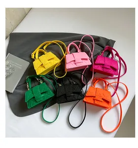 Macro shot of colorful mini square handbags featuring quilted patterns and top handles