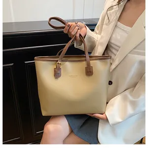 Detail of premium beige tote bag with brown leather straps and fashion branding logo