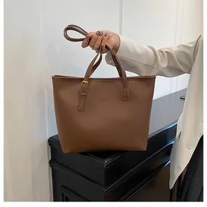Close-up of premium chocolate brown tote bag showing gold lettering and adjustable strap