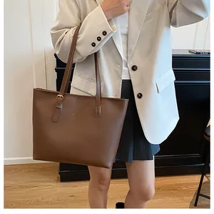 Brown leather tote bag styled with a beige suit for a professional business casual look